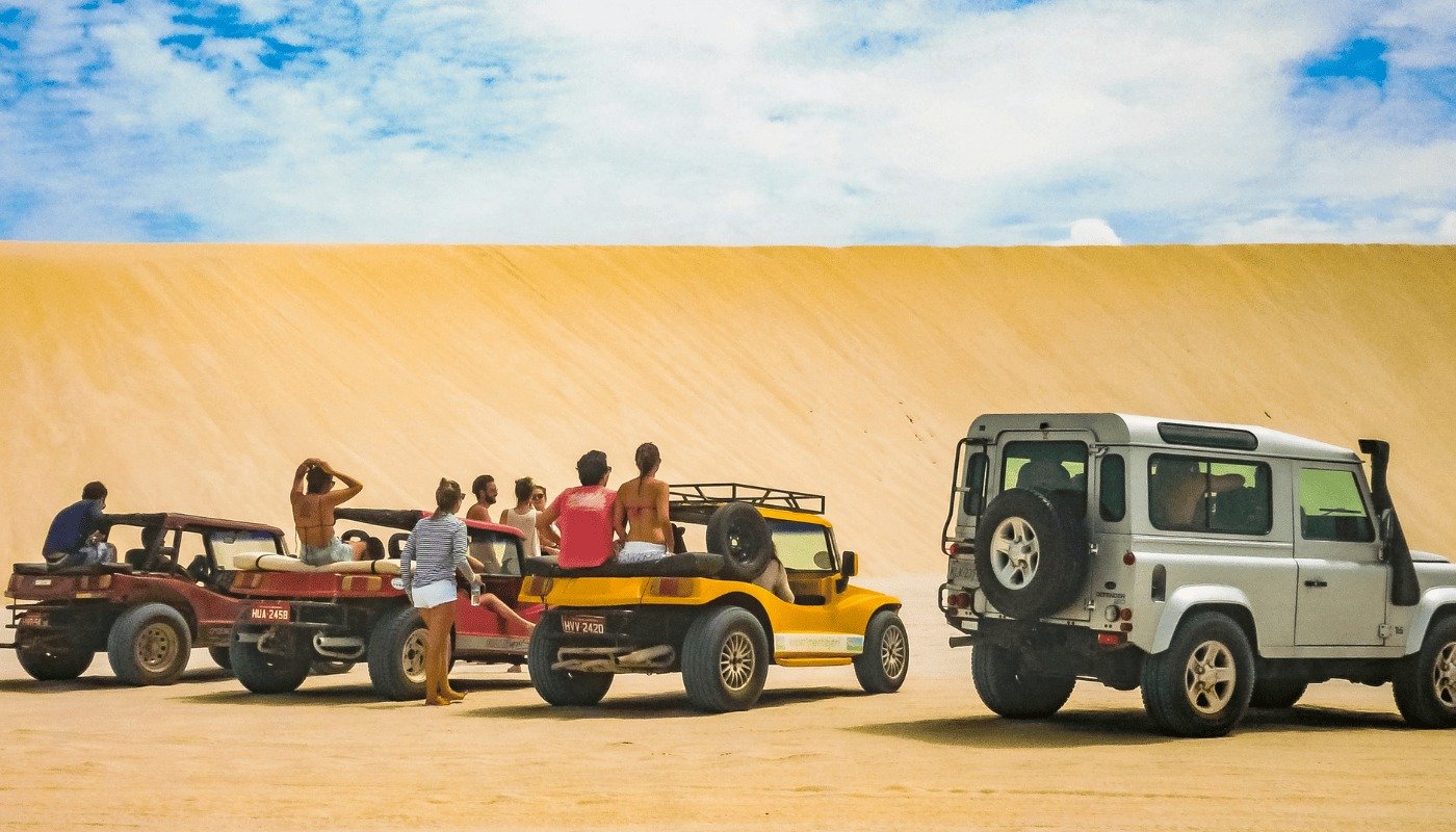 Passeio de buggy pelas dunas de Jericoacoara com visitantes durante roteiro turístico pelo litoral cearense